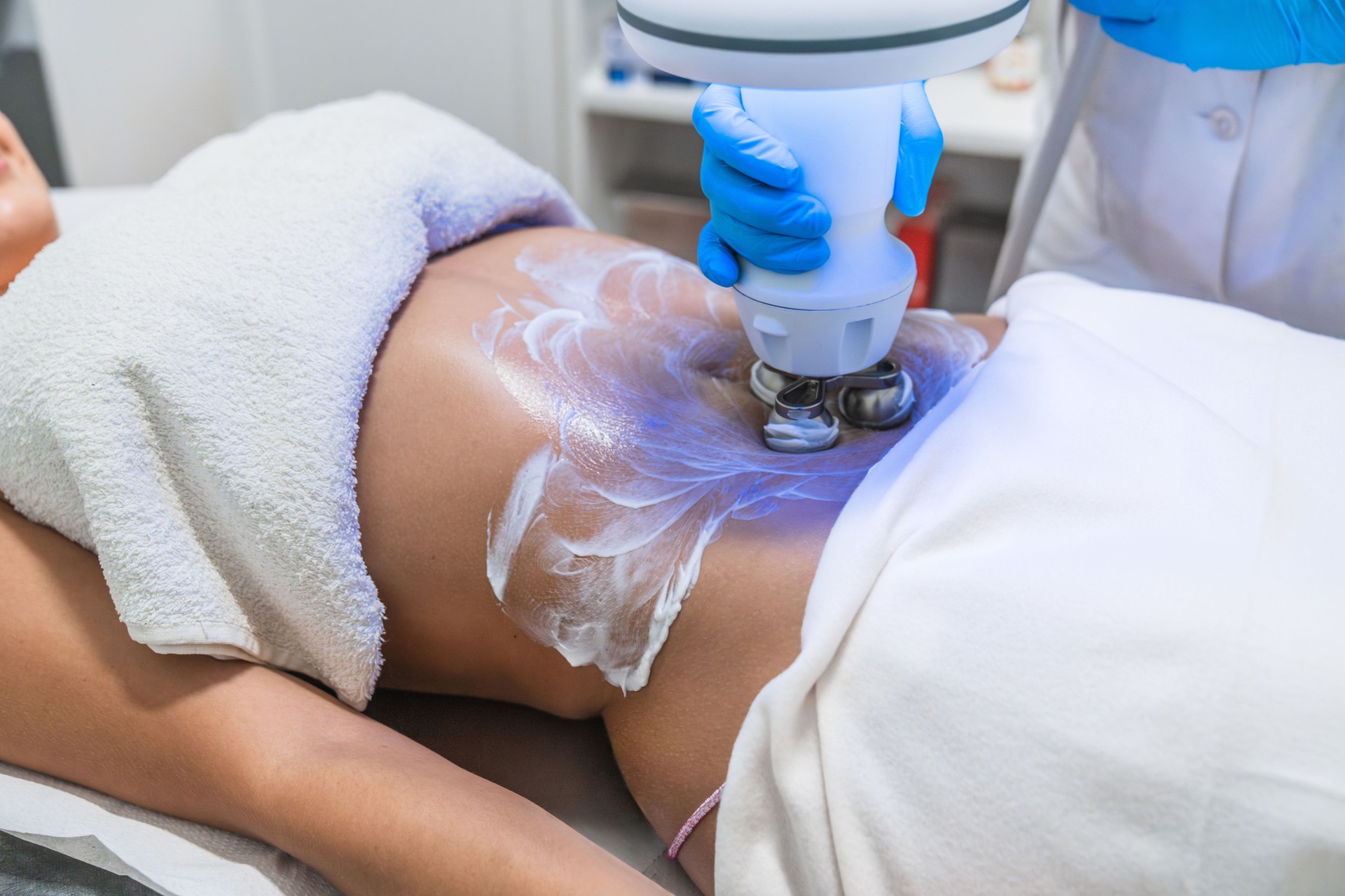 Beautician applying gel for hardware body shaping procedure